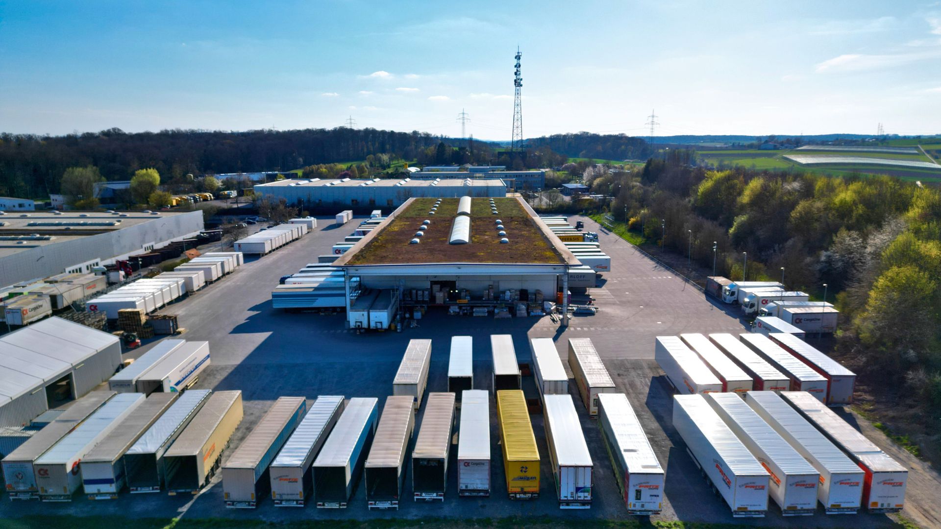 Luftaufnahme eines großen Lagers der Fritz Gruppe mit zahlreichen Lkw auf dem Gelände.